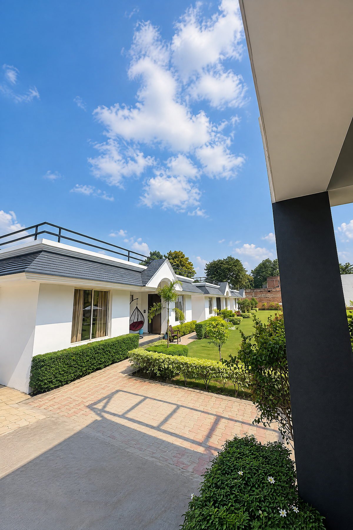 Guest cottage block seen across the manicured garden at The White House Pilibhit