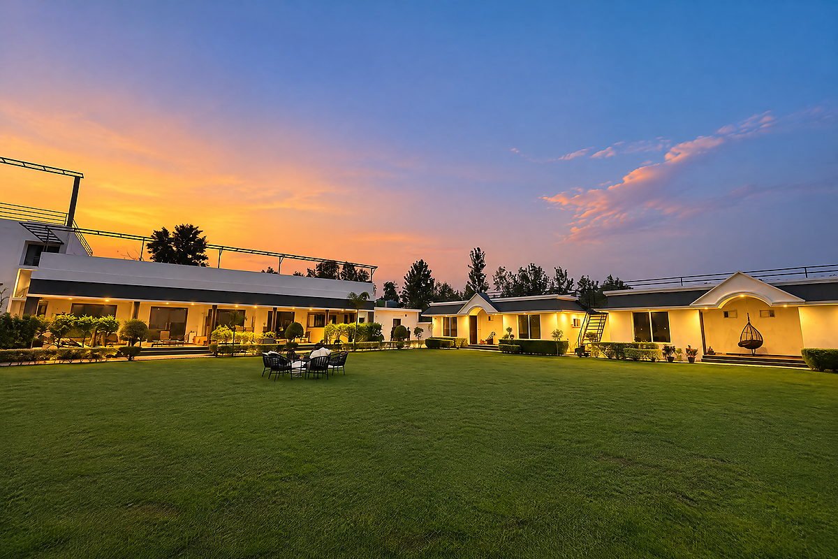 Wide dusk view of the event lawn and lit buildings at The White House Pilibhit