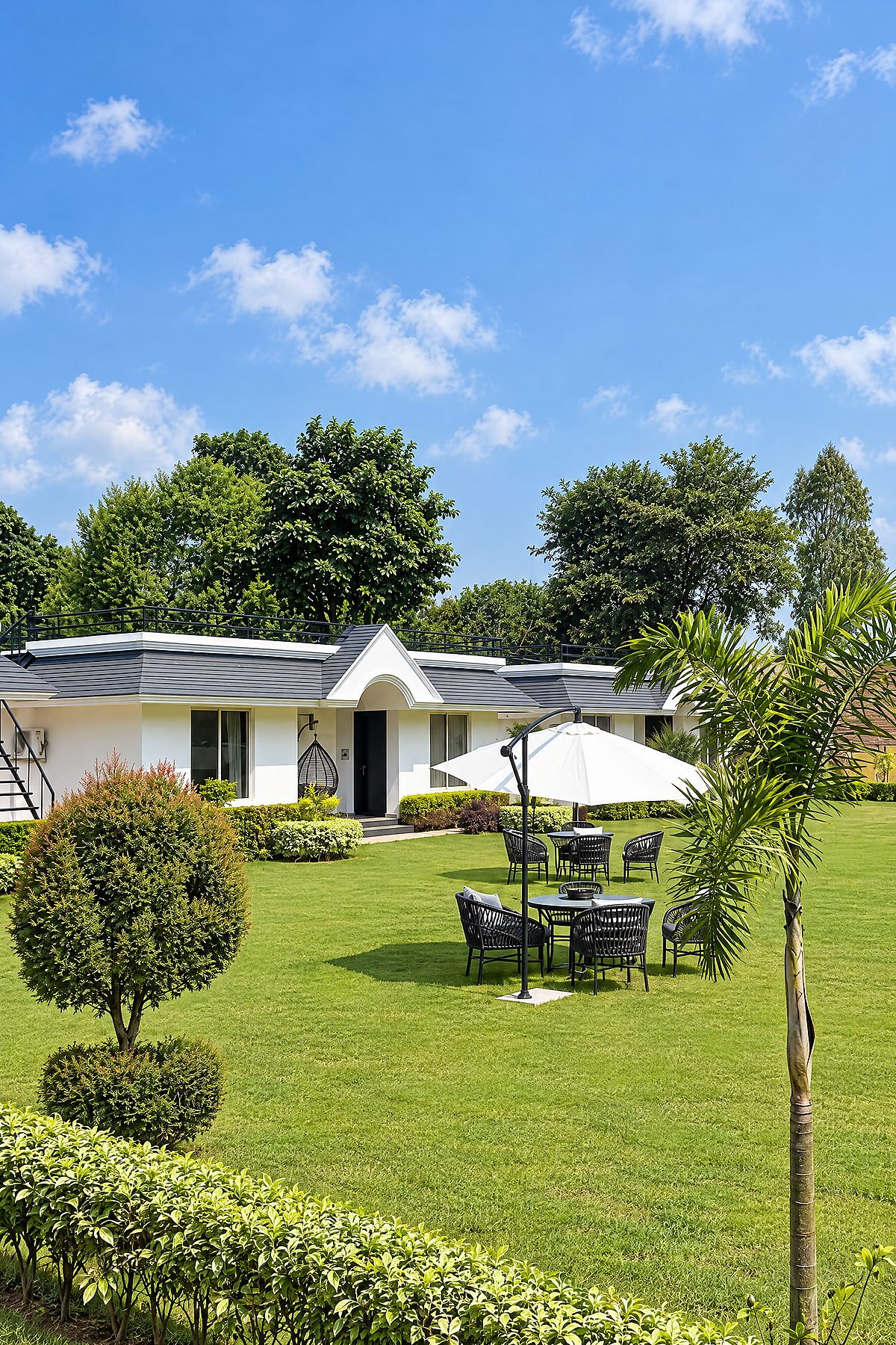 Landscaped lawn and garden seating in front of the cottages at The White House Pilibhit