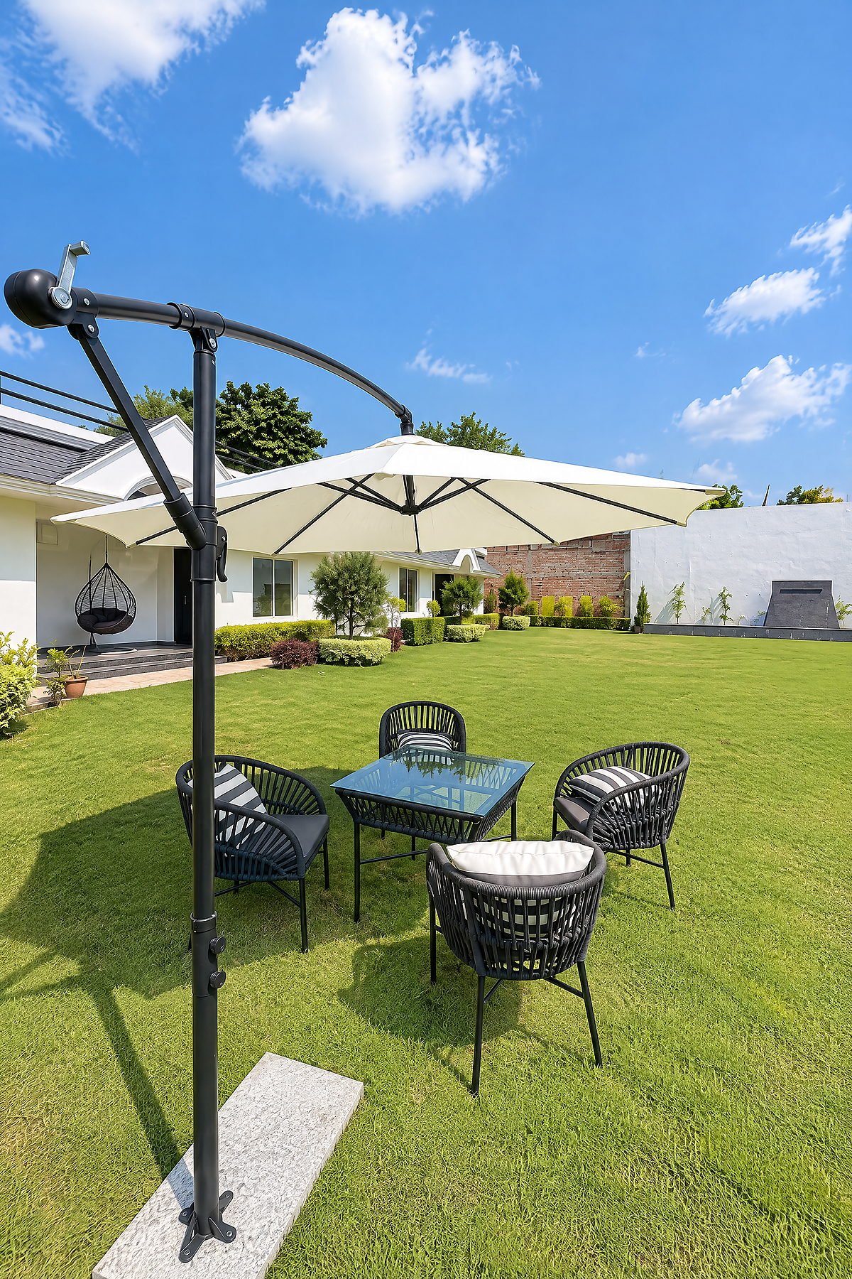 Garden dining set under a parasol on a clear day at The White House Pilibhit