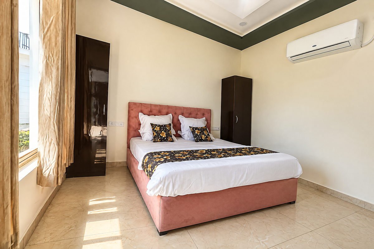 Guest room with a double bed, wardrobe and natural light at The White House Pilibhit