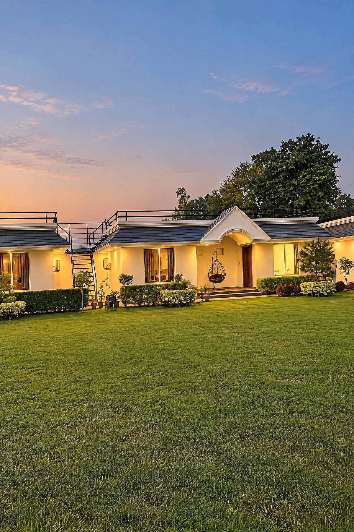 Lawn and guest cottages at twilight at The White House Pilibhit