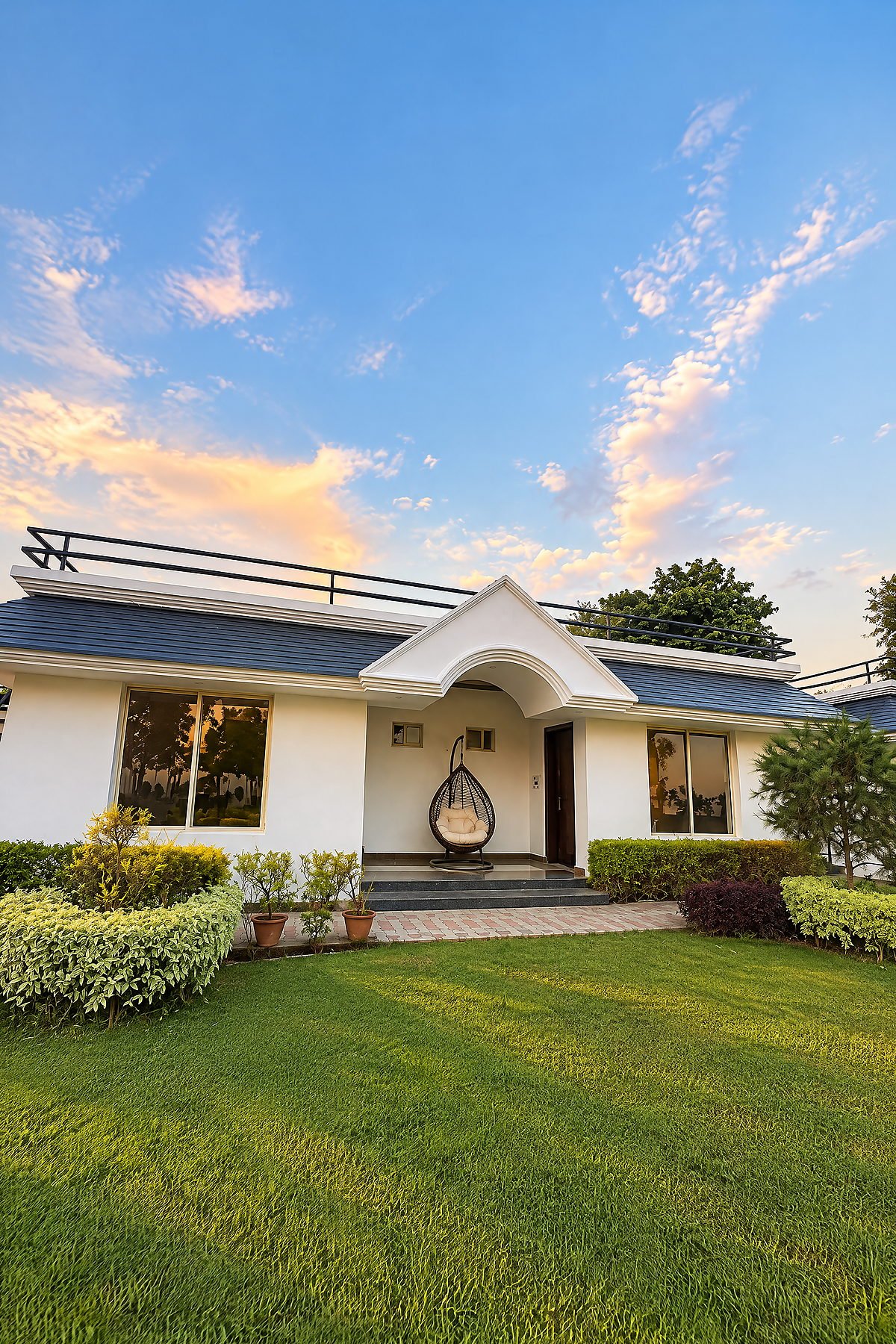 The white villa entrance under a blue evening sky at The White House Pilibhit