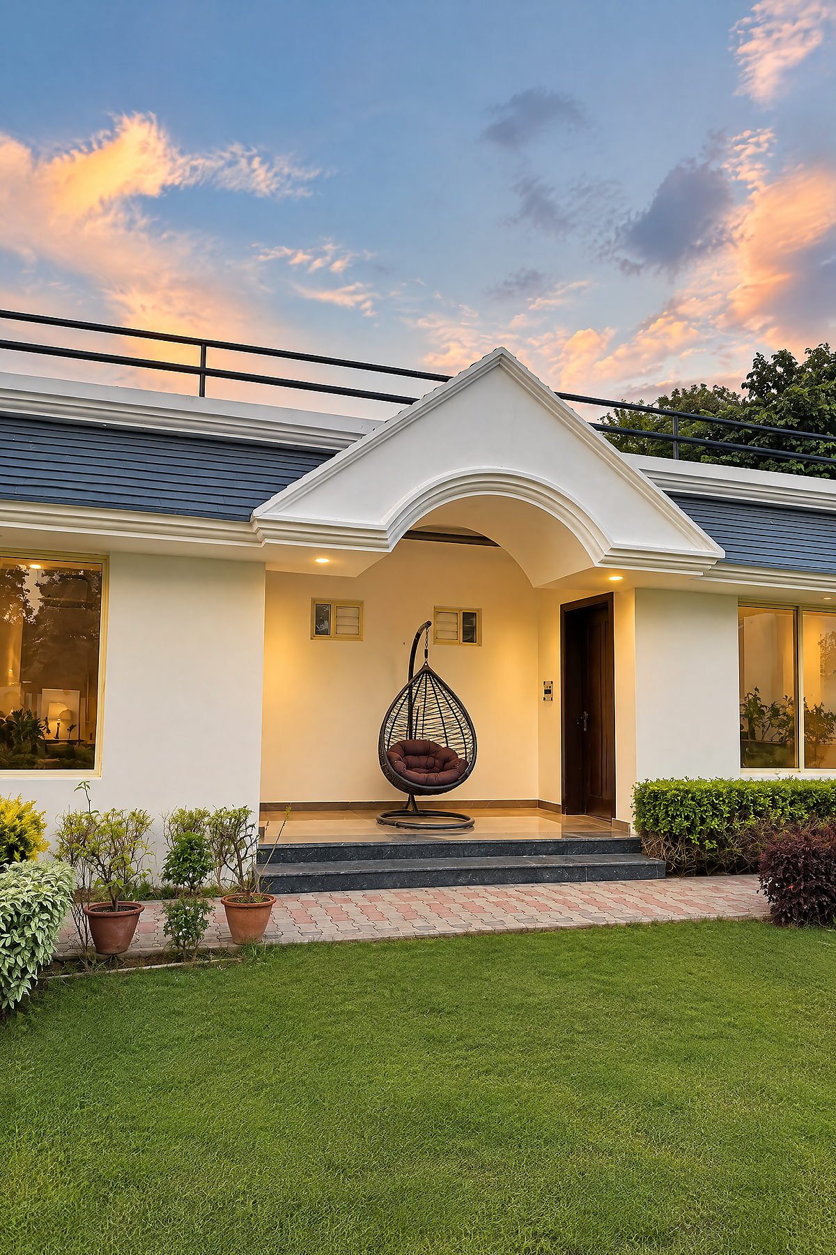 The arched villa entrance and clipped hedges at dusk at The White House Pilibhit