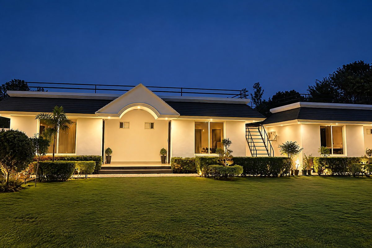 The white villa and lawn illuminated at night at The White House Pilibhit